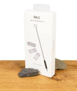 PAX Wartungsset in der Originalverpackung auf einem Holztisch, bestehend aus Pfeifenreinigern und Ersatzteilen.